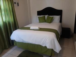 a bedroom with a large bed with green curtains at Thula Du Estate - family houses in Mbabane +40 photos