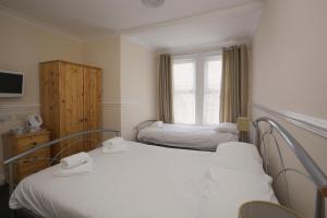 Habitación pequeña con 2 camas y ventana en All Seasons Lodge Hotel en Great Yarmouth