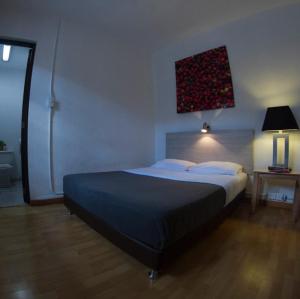 a bedroom with a large bed and a lamp at Explora Hostels in Bogotá