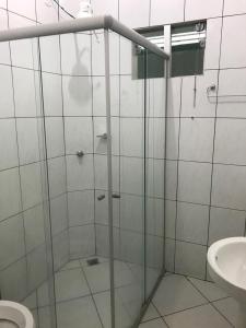 a bathroom with a glass shower with a toilet at Hotel Master in Primavera do Leste