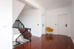 a hallway with a staircase and a yellow chair at Volcanic Charming House in Ribeira Grande