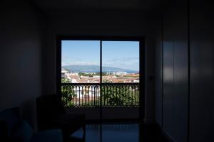 a room with a window with a view of a city at Volcanic Charming House in Ribeira Grande