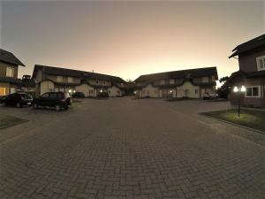ein Parkplatz mit Autos vor den Häusern geparkt in der Unterkunft Sua Casa em Canela in Canela