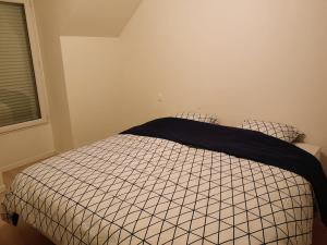 a bedroom with a bed with a black and white comforter at Maison récente calme 24 heures du Mans 9 couchages in Le Mans