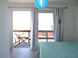 Habitación con mesa y vistas a un balcón. en Ammunaini en Punta Del Diablo