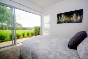 a bedroom with a bed and a large window at The Rise in Waimate North +25 photos