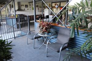 un patio con sillas, una mesa y un bar en Gecko Guest House en Cooktown