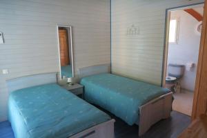 a small room with two beds and a mirror at Le Campagnol in Saint-Justin +15 photos