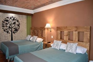 una habitación de hotel con 2 camas en una habitación en Hotel Ana Catalina and Suites, en San Miguel de Allende