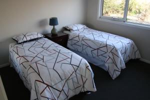 dwa łóżka siedzące obok siebie w sypialni w obiekcie Penguin Seaside Farm w mieście Penguin