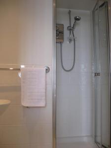 a bathroom with a shower with a white towel at Aquarium Guest House in Brighton & Hove +35 photos