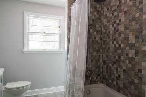 a bathroom with a toilet and a window at Boho by the Water! 1750sqft - Fishing & sleeps 10! in Charlotte +20 photos