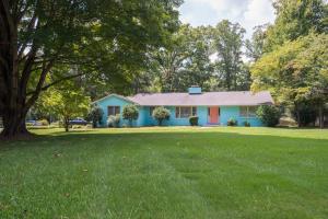 a blue house with a red door on a yard at Boho by the Water! 1750sqft - Fishing & sleeps 10! in Charlotte