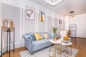 a living room with a blue couch and a table at Zhengzhou Jinshui·Manhattan Commercial Plaza· Locals Apartment 00163340 in Zhengzhou