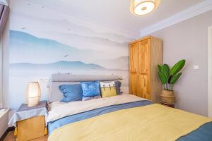 1 dormitorio con 1 cama con una pintura en la pared en Zhengzhou Zhongyuan·Zhongyuan Wanda· Locals Apartment 00159010, en Zhengzhou