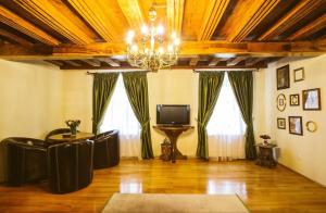 a living room with a chandelier and a tv at Casa Schobeln in Braşov