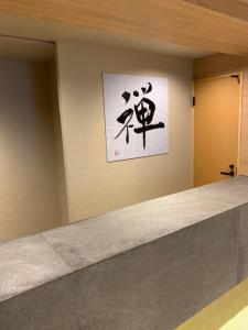 a wall with a painting on a wall with a counter at Hotel Be-zen shimanouchi in Osaka