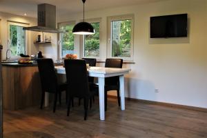 a kitchen with a white table and chairs in a kitchen at Cormanns Hüttchen in Schmallenberg