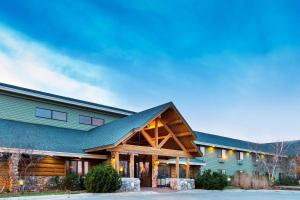 una casa grande con techo de gambrel en AmericInn by Wyndham Chamberlain Conference Center, en Chamberlain