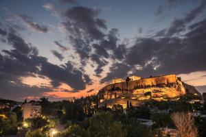 um castelo no topo de uma montanha ao pôr-do-sol em Splash Of Glam I 10 steps from Acropolis em Atenas