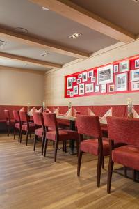 AKZENT Hotel Zur Post في تابارز: غرفة طعام مع طاولة طويلة وكراسي حمراء