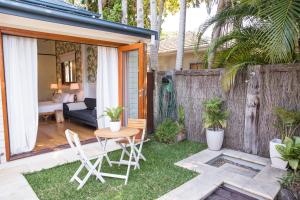 een kleine achtertuin met een tafel en stoelen bij Bayhaven Lodge in Byron Bay