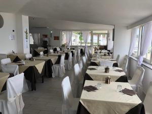 a restaurant with white tables and white chairs and tablesearcher at Pizzo Beach Club by Maralp in Pizzo