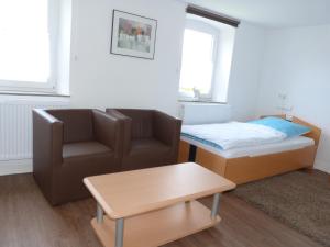 sala de estar con sofá, cama y silla en Super schöne Fewo en Aalen