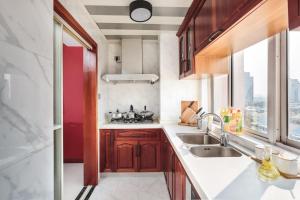 a kitchen with wooden cabinets and a sink and a window at NanJing GuLou·Lion Bridge· Locals Apartment 00152470 in Nanjing