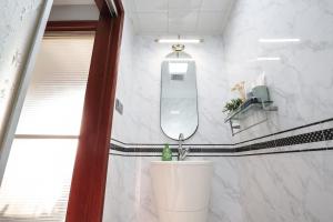 ein Badezimmer mit Waschbecken und Spiegel in der Unterkunft NanJing GuLou·Lion Bridge· Locals Apartment 00152470 in Nanjing + 22 Fotos