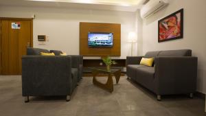 a living room with two couches and a tv at SPACE Luxury Rental Suites in Rawalpindi