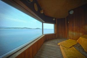 a boat with a bed and a large window at Minami Sanriku Hotel kanyo in Shizukawa