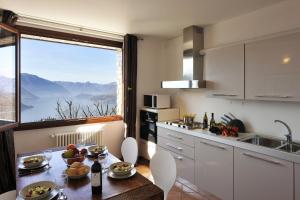 a kitchen with a table and a large window at Alto Perledo Terrazzo in Perledo