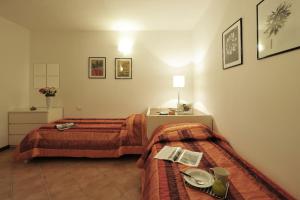 ペルレードにあるAlto Perledo Terrazzoのベッド2台とテーブルが備わるホテルルームです。