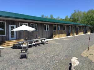 a picnic table and an umbrella in front of a building at Farm Retreat with 2 Bed Roms perfect for 4 Guests! in Deep Brook