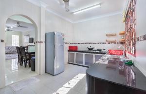 eine Küche mit einem Kühlschrank und einem Tisch darin in der Unterkunft Homestay Rini Zikry in Skudai