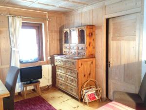 a bedroom with a dresser and a television in a room at Chasa Anguel in Samnaun
