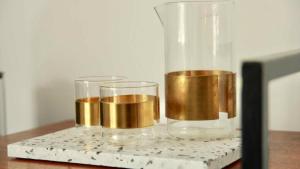 two glasses sitting on a table with a vase at huisalfons in Mechelen