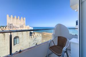 Un balcón con una silla y vistas al océano. en Hotel La Española, en Chipiona