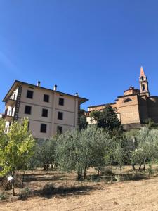 un bâtiment, une église et des arbres dans un champ dans l'établissement Casa FONTESECCA, à Castiglion Fiorentino