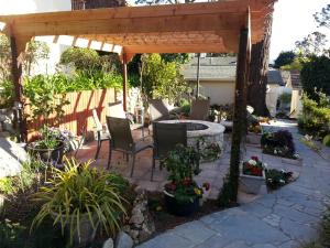 um pátio com uma pérgola, uma mesa e cadeiras em The Vendange Carmel Inn & Suites em Carmel