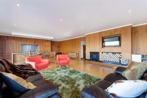 a living room with a couch and two chairs and a television at Luxe Home on the Hill in Queenstown