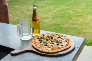 una pizza en una mesa junto a una botella de cerveza en Beleza By The Beach, en Colva
