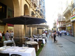 a street with tables and chairs and an umbrella at Logrocity Corazon de Logroño PARKING PRIVADO GRATIS in Logroño