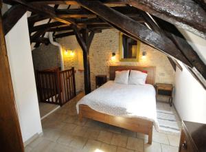 ein Schlafzimmer mit einem Bett im Dachgeschoss in der Unterkunft Le Passage in La Charité-sur-Loire