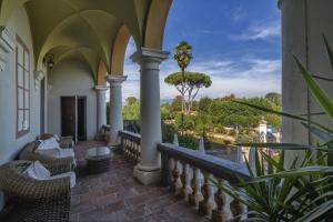 Un balcón con sillas y vistas al océano. en Hotel Villa Cheli en Lucca