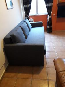 un sofá azul sentado en una sala de estar en Governor's Inn Apartments, en Gibraltar