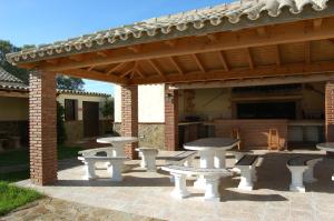 a patio with picnic tables and a pavilion at Residencial La Teja in Zahora