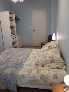1 dormitorio con 1 cama con colcha de flores en Maison de village, en Bagnols-en-Forêt