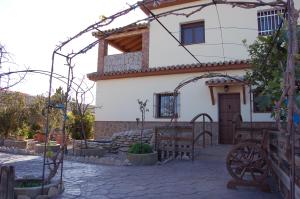 a house with an arch and a bench in front of it at Residencial La Teja in Zahora